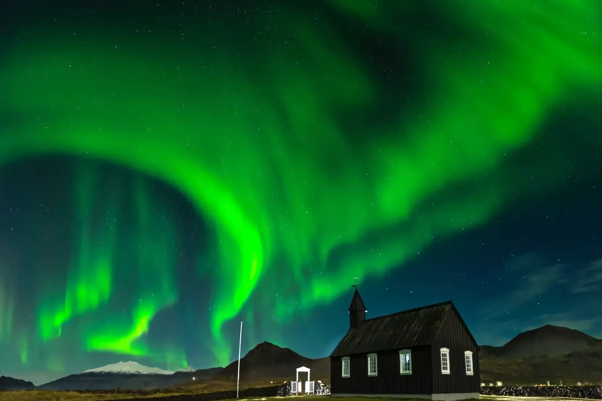 Northern lights over Búðakirkja black church in Iceland