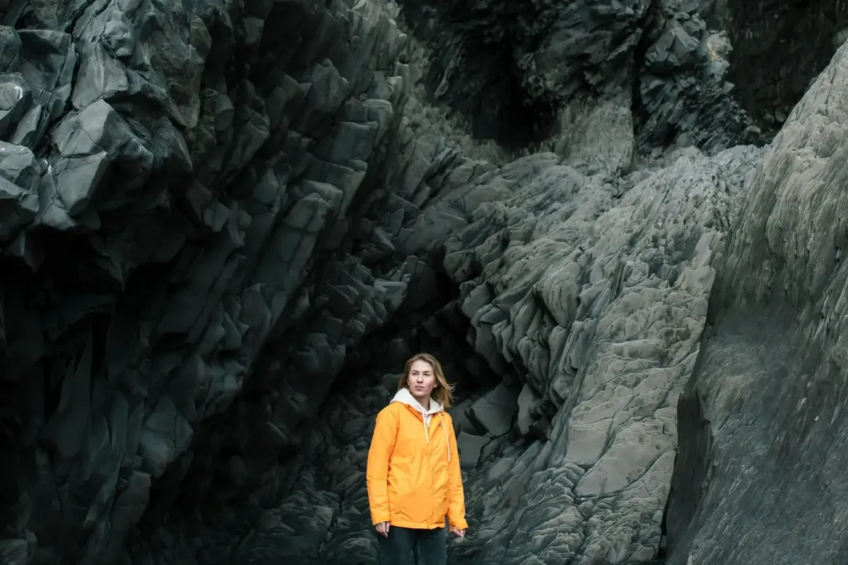 Traveller resting in a cave on Reynisfjara black sand beach